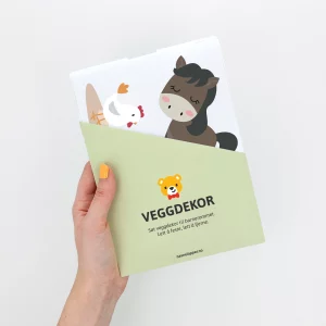 En hånd med oransje neglelakk viser en emballasje med veggdekor