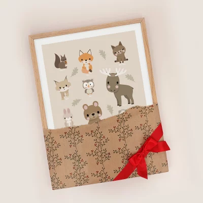 Plakat med skogsdyr i ramme pakket i julepapir med sløyfe på.
