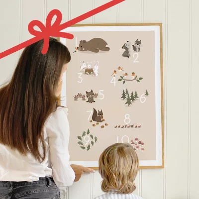 Voksen og barn som ser på en tallplakat med skogsdyr på veggen.