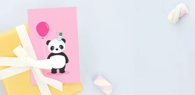 Barnebursdagskort med dyremotiver, inkludert en panda, en gris, og en løve, kombinert med fargerike ballonger og festhatter, plassert ved en gave innpakket i gult papir med hvitt bånd.