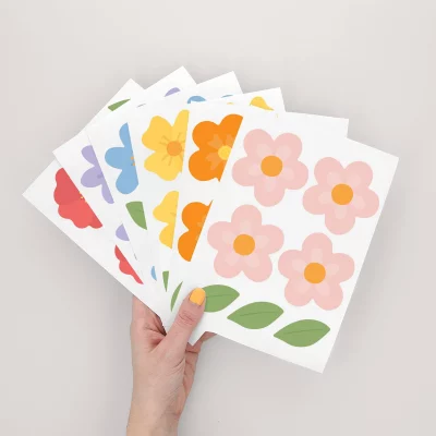 Hånd som holder veggdekor med markblomster