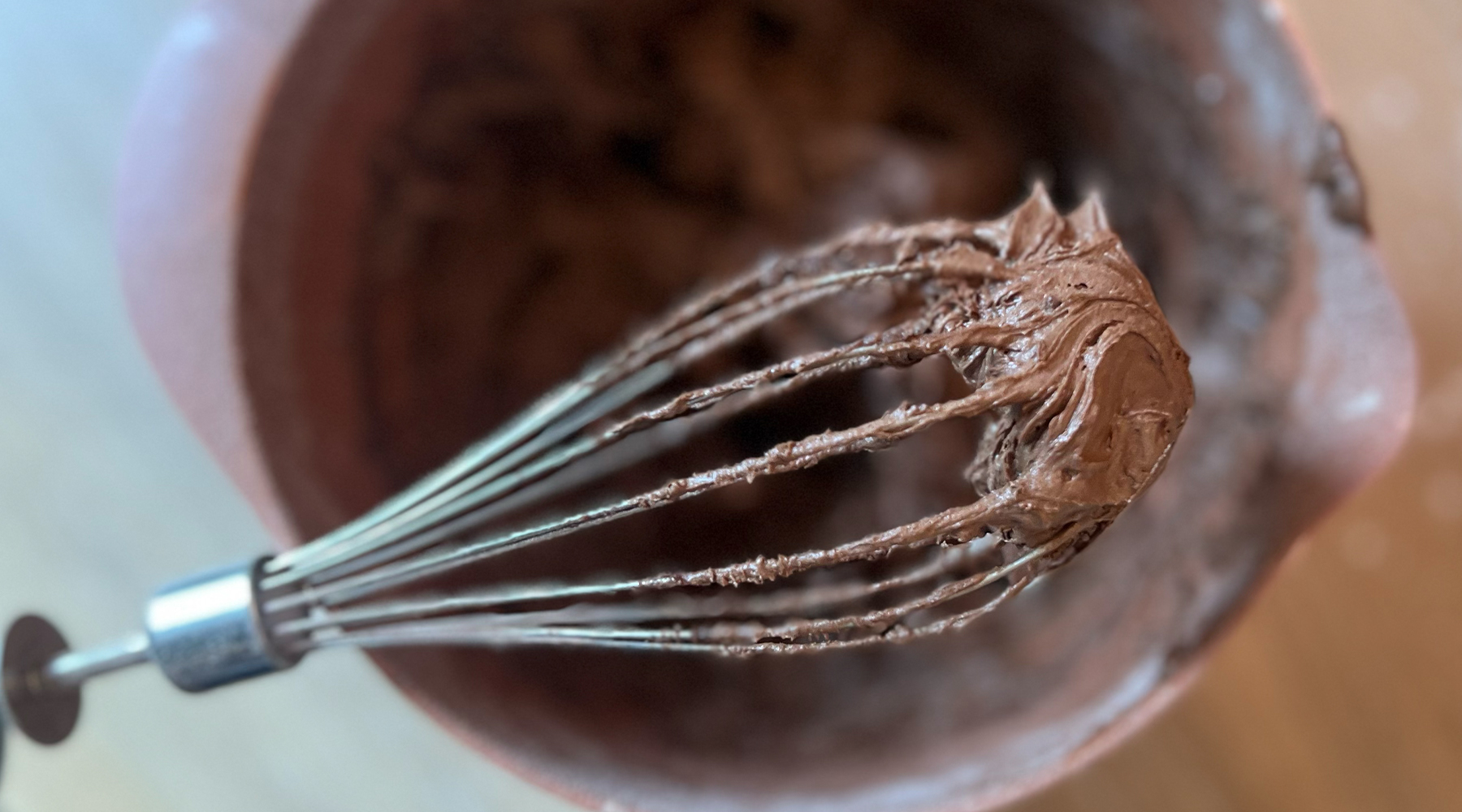 En visp med sjokoladerøre i en bolle, perfekt for å illustrere baking til barnebursdager. 