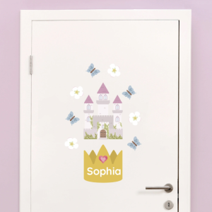 En vakker veggdekorasjon for barn som viser et eventyrlig slott med rosa tak, omgitt av sommerfugler og blomster. Navnelappen Sophia er plassert under et prydende krone-design, noe som gir en personlig og unik touch til rommet. Perfekt for barnerommet for å skape en magisk atmosfære.